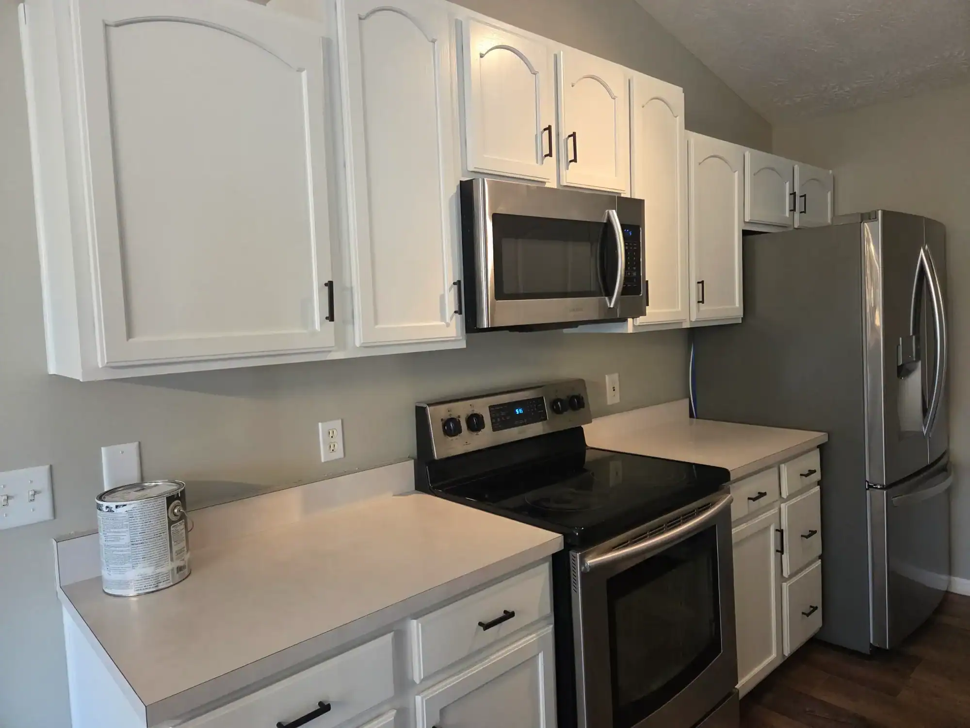 Cabinet painting services West Chester - white kitchen cabinets with stainless appliances and gray walls