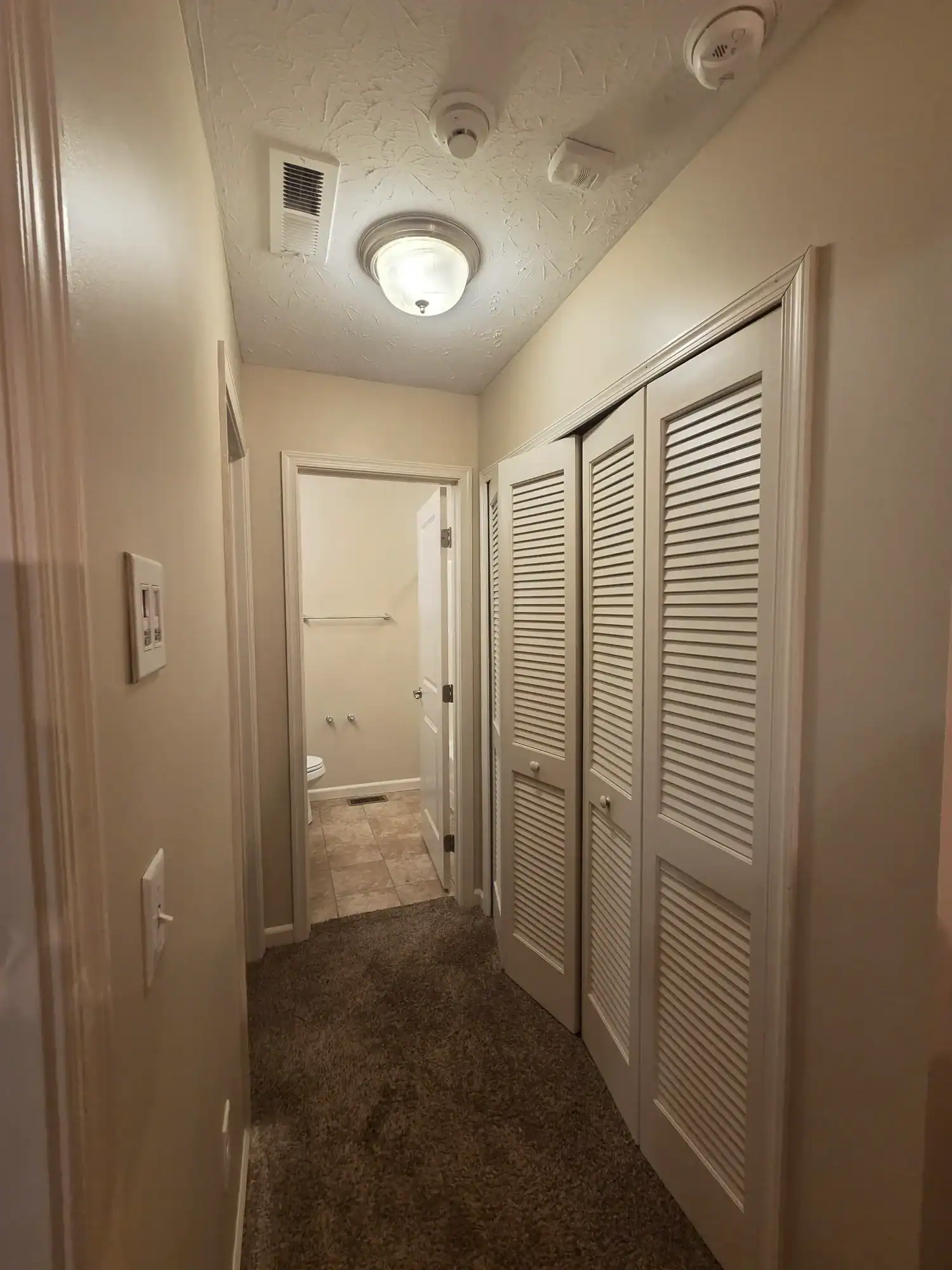 Professional painters Cincinnati - beige hallway with white louvered doors and quality interior painting