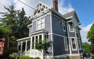 Residential painting services Mason - stunning purple Victorian home with white trim and decorative details