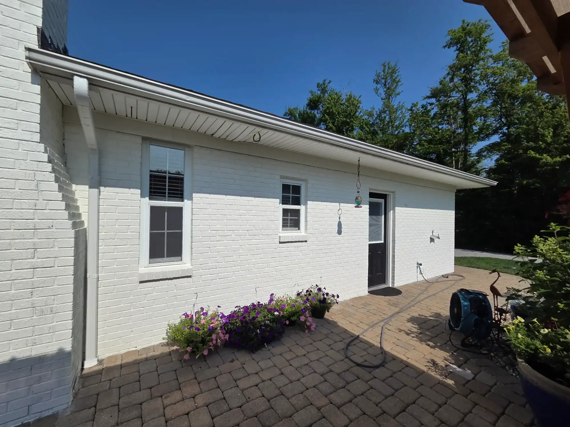 House painting Mason Ohio - white painted brick home with purple flowers and professional exterior work
