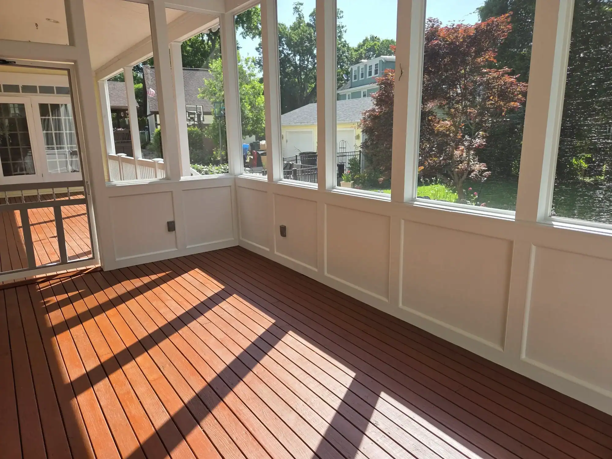 Professional deck painting Cincinnati - screened porch with wood floor and white wainscoting