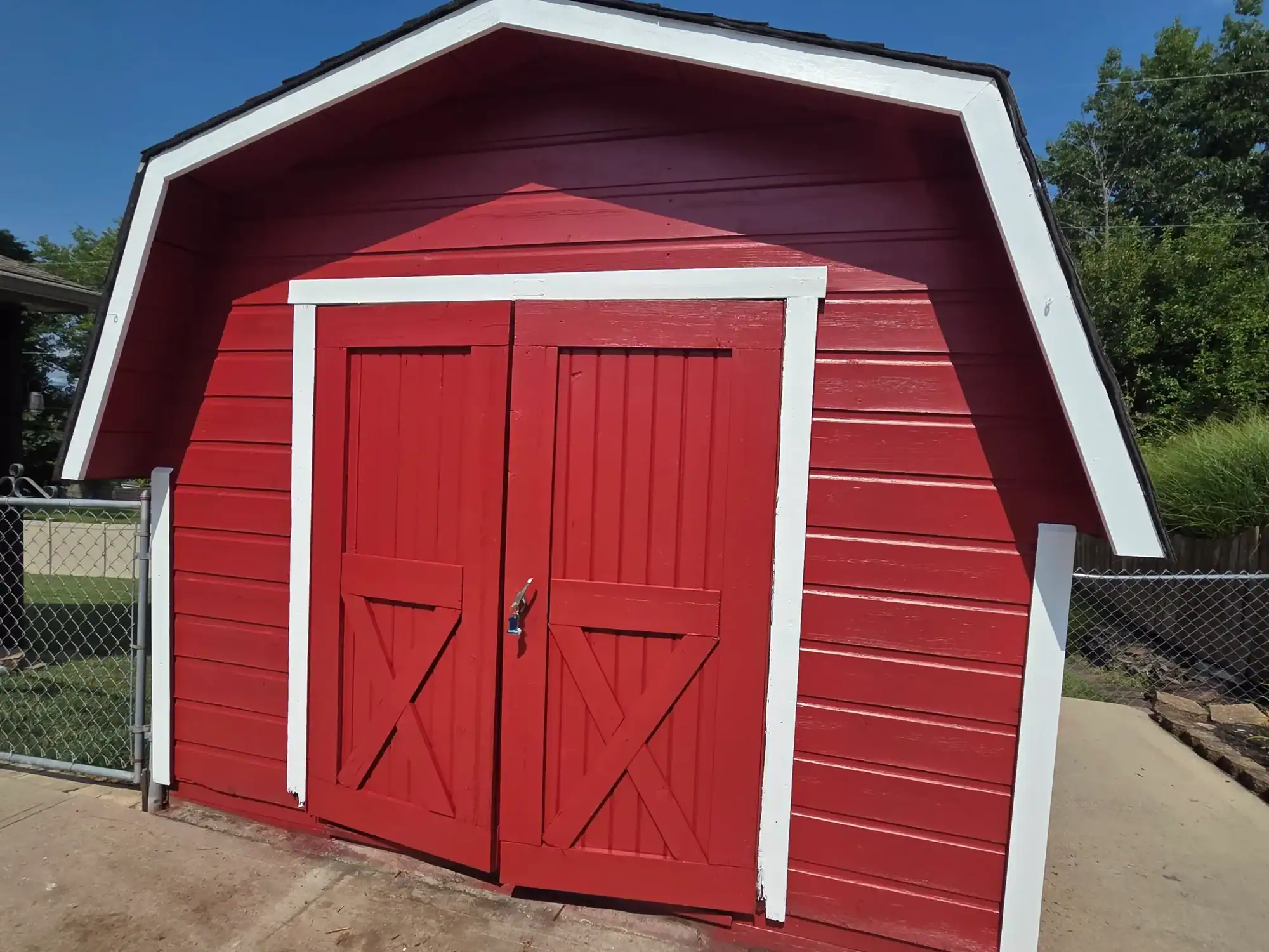 Exterior painting Hamilton Ohio - bright red barn-style shed with white trim and professional finish